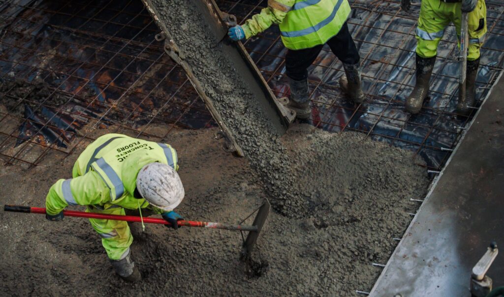 Concrete being discharged and raked into a reinforced bay on a Technic pour, the stage at which cube samples are taken